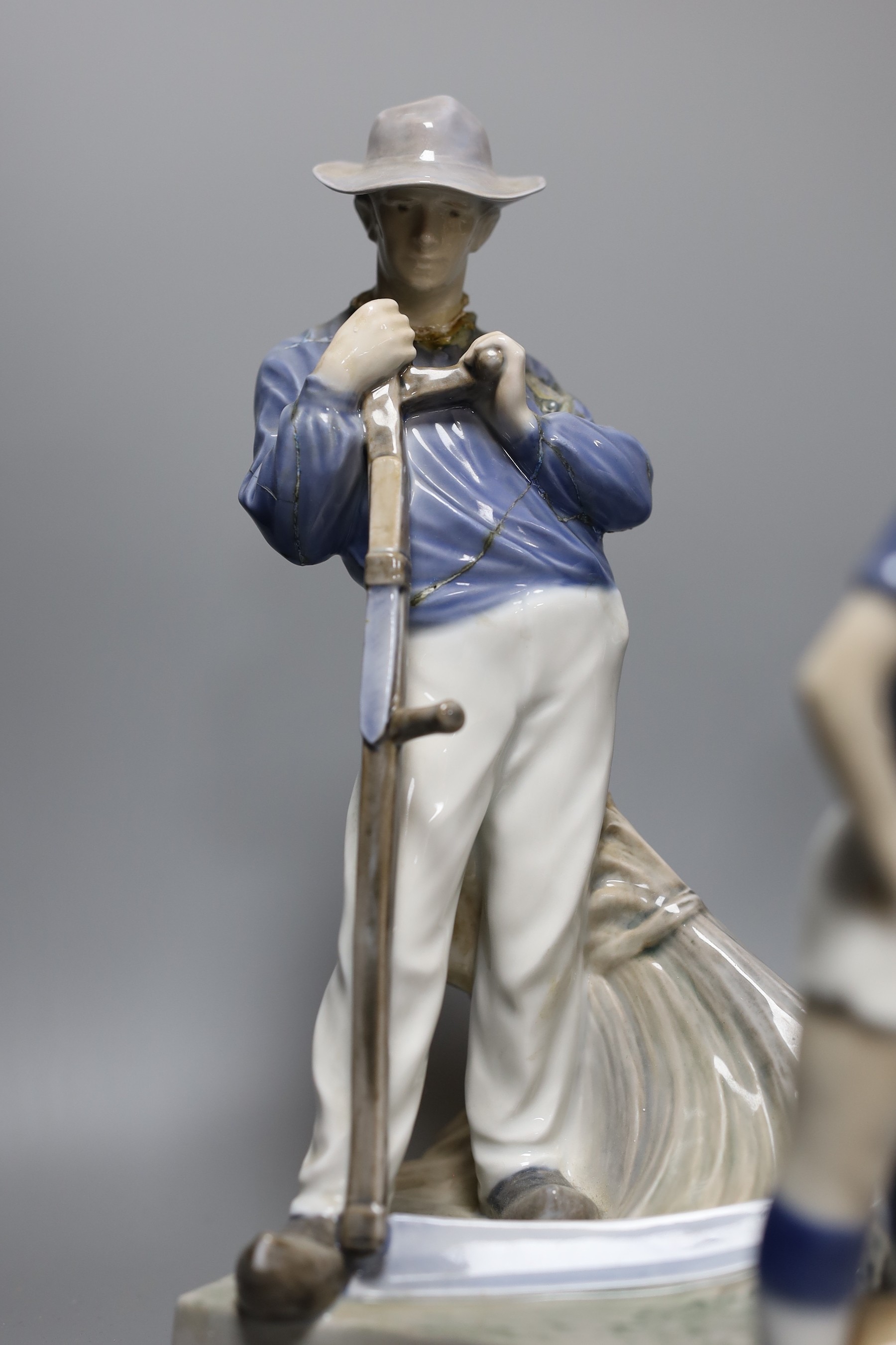 Eight pieces of Royal Copenhagen, to include a seated cat 340, Christmas Rose and Cat plate, a seated farm boy 4539, a young footballer 5657, two floral vases 2630 2289 and 57/251 K.P, a seated huntsman with dog 1087, an
